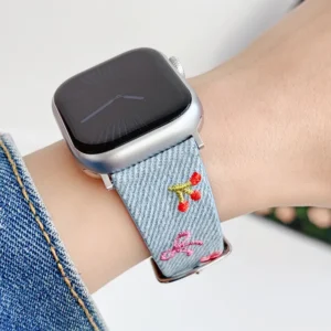 Light blue denim style vegan leather apple watch strap for women with embroidered cherries and pink bows.