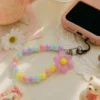 Durable pastel daisy pink beaded phone strap for women featuring a lightweight acrylic bead chain and a silver metal clasp.