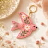 Pink floral AirTag keyring on a purse — cute vegan leather bag charm and gift for her.