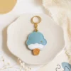 Blueberry ice cream cone vegan leather AirTag case in dusty blue and cream with gold keyring, cute AirTag holder for women