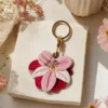 Yellow lily AirTag case clipped to a handbag strap, vegan leather AirTag holder for women