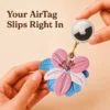 Apple AirTag snapped securely into the back shell of a pink and blue vegan leather lily AirTag case