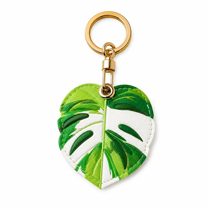 Monstera leaf vegan leather AirTag case in green and white with gold keyring clasp, cute AirTag holder for women