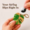 Caramel monstera leaf vegan leather AirTag case in tan and green with gold keyring, cute AirTag holder for women