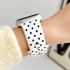 White silicone Apple Watch strap with black polka dots and pin-and-tuck clasp, comfortable replacement band for women