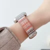 Slim coral boucle tweed Apple Watch band for women, comfortable vegan leather replacement strap with woven stripes.