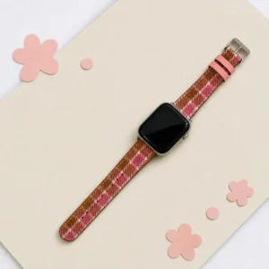 Slim rose tartan tweed Apple Watch band for women, comfortable vegan leather replacement strap in pink check.